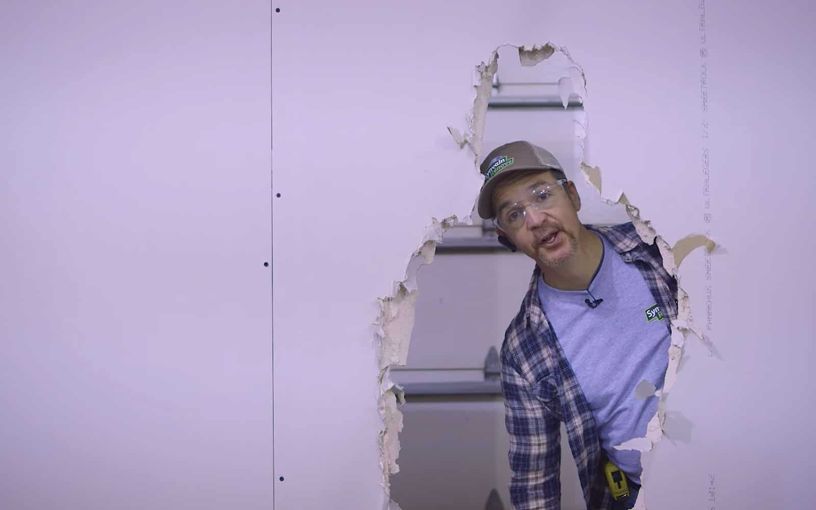 Synvain parle à travers un mur troué